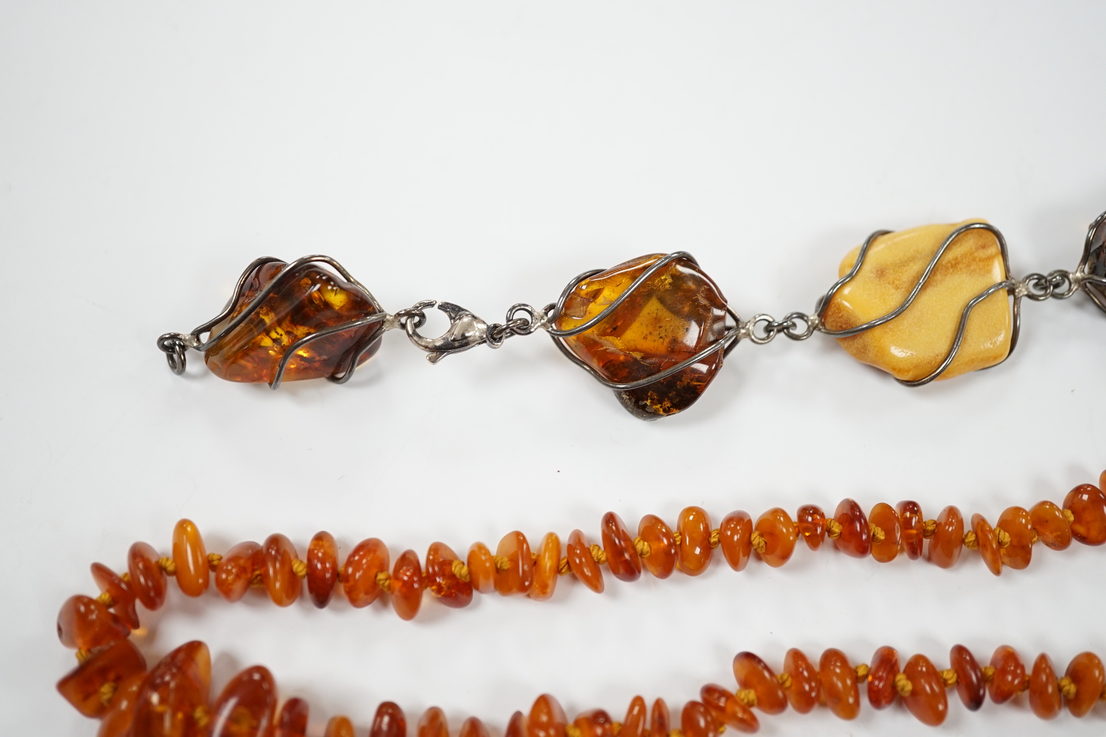 Two white metal and Baltic amber pebble set bracelets, one stamped 925, largest 25cm, a pair of similar drop earrings and an amber necklace.